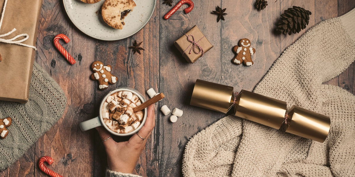 Holiday table with a hot drink, cookies, candy canes and gingerbread