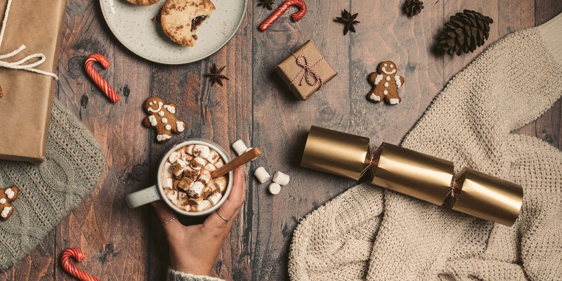 Holiday table with a hot drink, cookies, candy canes and gingerbread