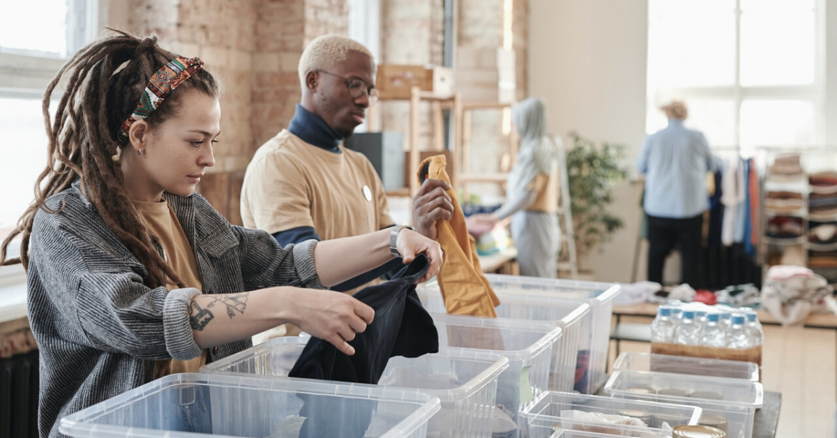 Volunteers sorting donated clothing into bins